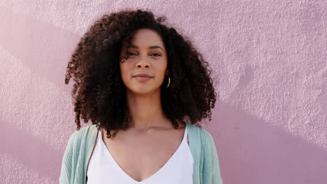 Funky-woman-shaking-natural-curly-hair-on-pink