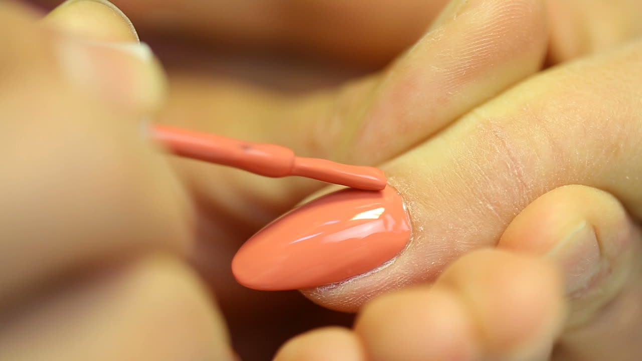 Closeup shot of a woman in a nail salon receiving manicure by beautician
