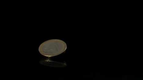 moneda de euro que cae sobre una superficie negra
