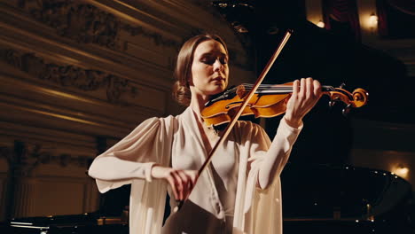 violinist performing in a grand concert hall