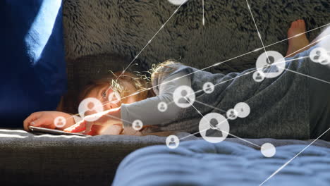 iconos de perfil interconectándose con líneas sobre chica caucásica usando teléfono inteligente mientras está acostada en el sofá