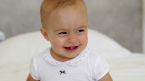 cute baby girl playing with towel on bed