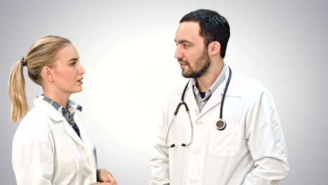 dos profesionales médicos discuten con un paciente en un fondo blanco