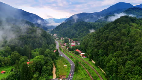 Winding mountain road through greenery. A winding road weaves through lush forests and hills, revealing nature&#039;s beauty under a cloudy sky