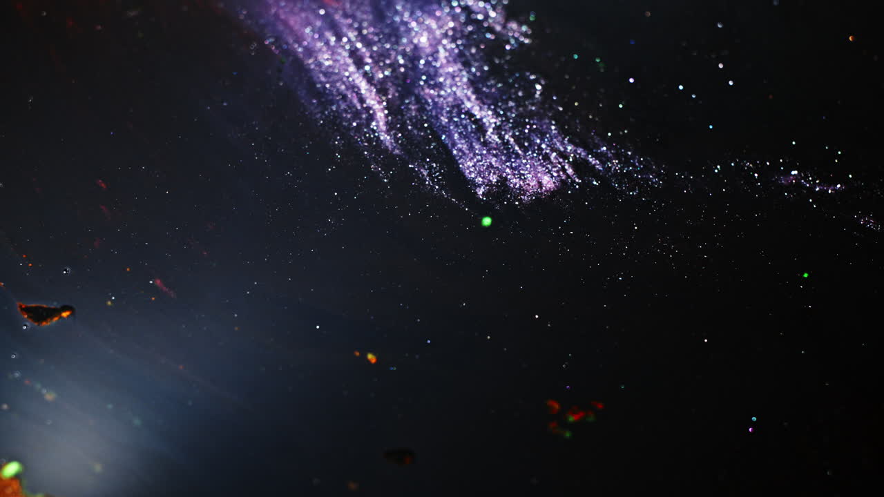 Kosmisk blækhvirvel, der blander farver i makro for en kreativ abstrakt effekt.