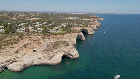 Aerial-view-of-the-Benagil-caves-with-a-group-of-kayaks-entering