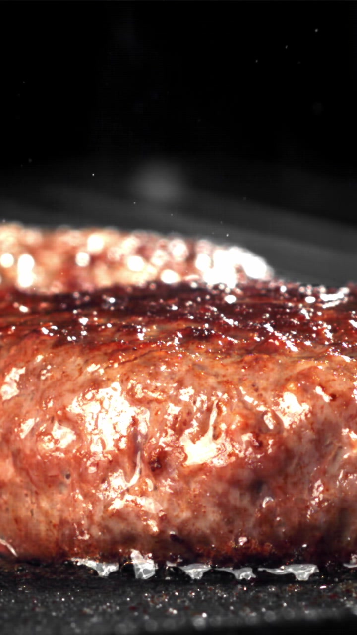 Close-up of a Juicy Burger Patty Sizzling on a Hot Grill