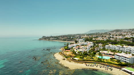 aerial view of the coastal town of mijas, spain, showcasing its beautiful shoreline, white buildings, and clear blue waters