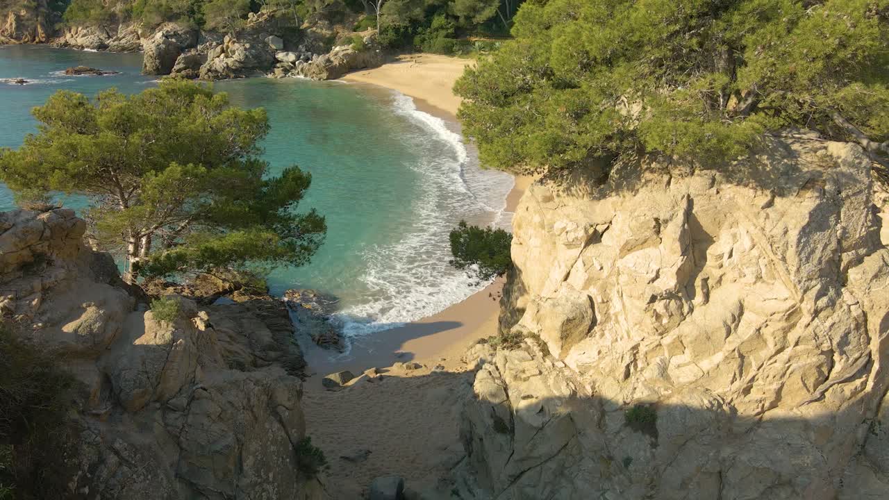 Vista aerea su una spiaggia esotica con acqua cristallina e grandi rocce sulla riva.