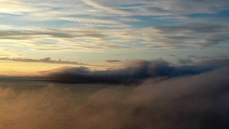 flying through ocean with rolling clouds on misty morning. - timelapse