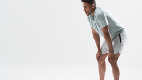 Young-biracial-athlete-man-takes-a-break-from-exercising-on-a-white-background,-with-copy-space