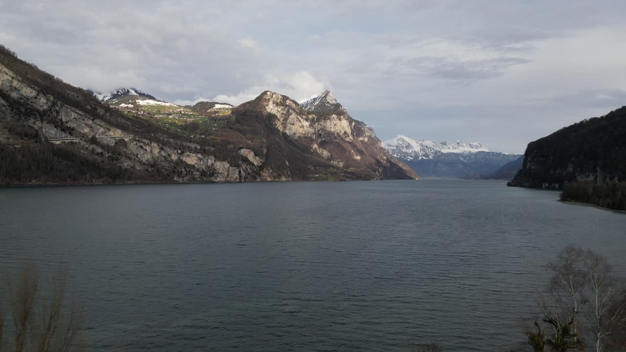 las aguas del lago azotadas por el viento en walensee, suiza, con el sol brillando y destacando los picos de las montañas expuestos.