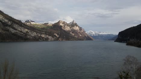 windswept lake waters in walensee switzerland with sun shining and highlighting exposed mountain peaks