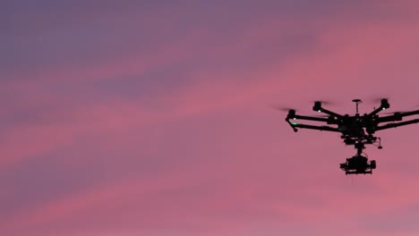 dji s900 mega drone volando con puesta de sol rosa en el fondo