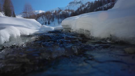 cerrar la escorrentía de agua dulce de la nieve derretida en un día soleado, primavera en las montañas