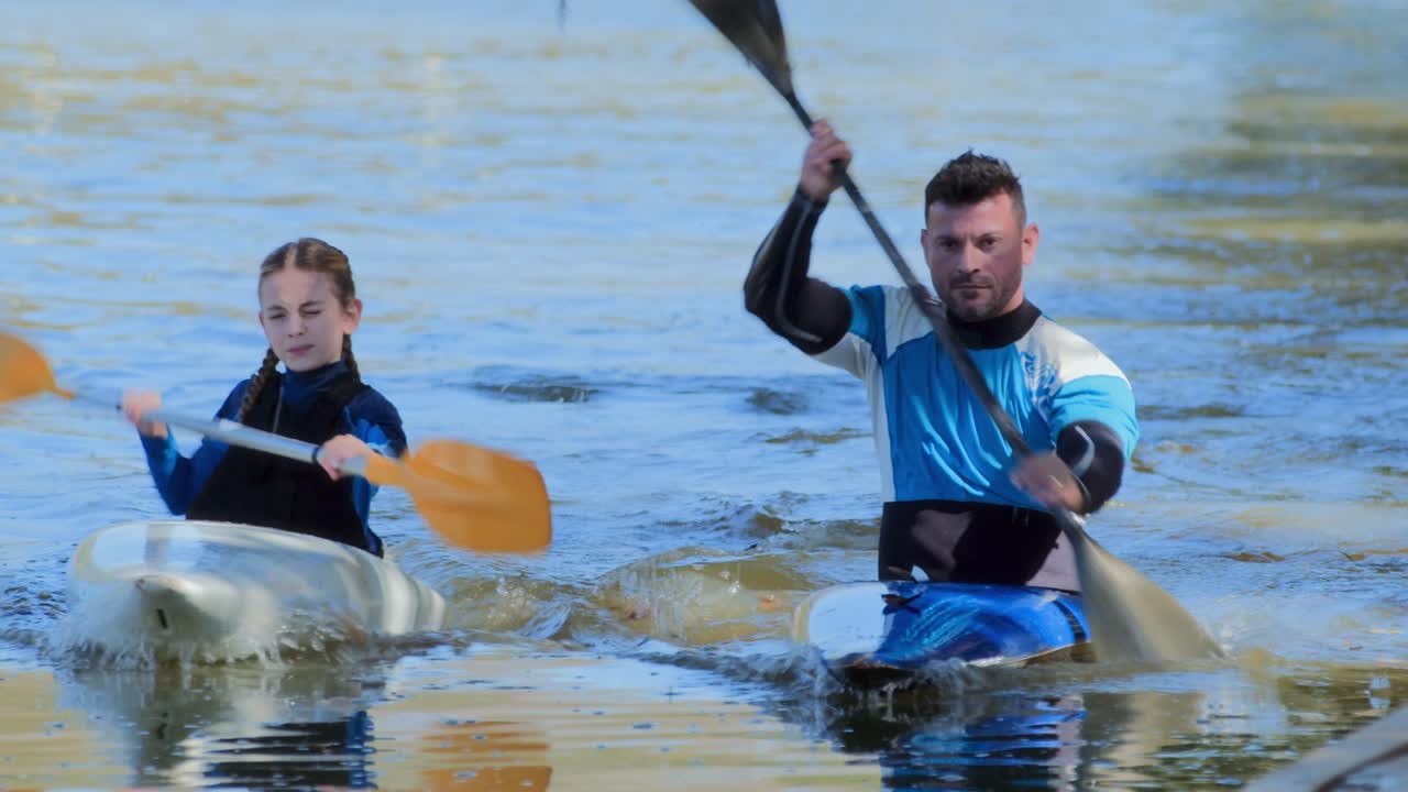 Two Kayakers Paddling on a River