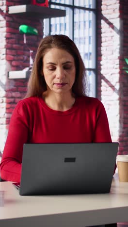 vertical video mature girl freelancer managing her creative projects remotely in loft