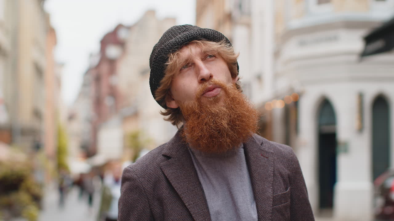 Portrait of young bearded man tourist walking in urban city street smiling having positive good mood