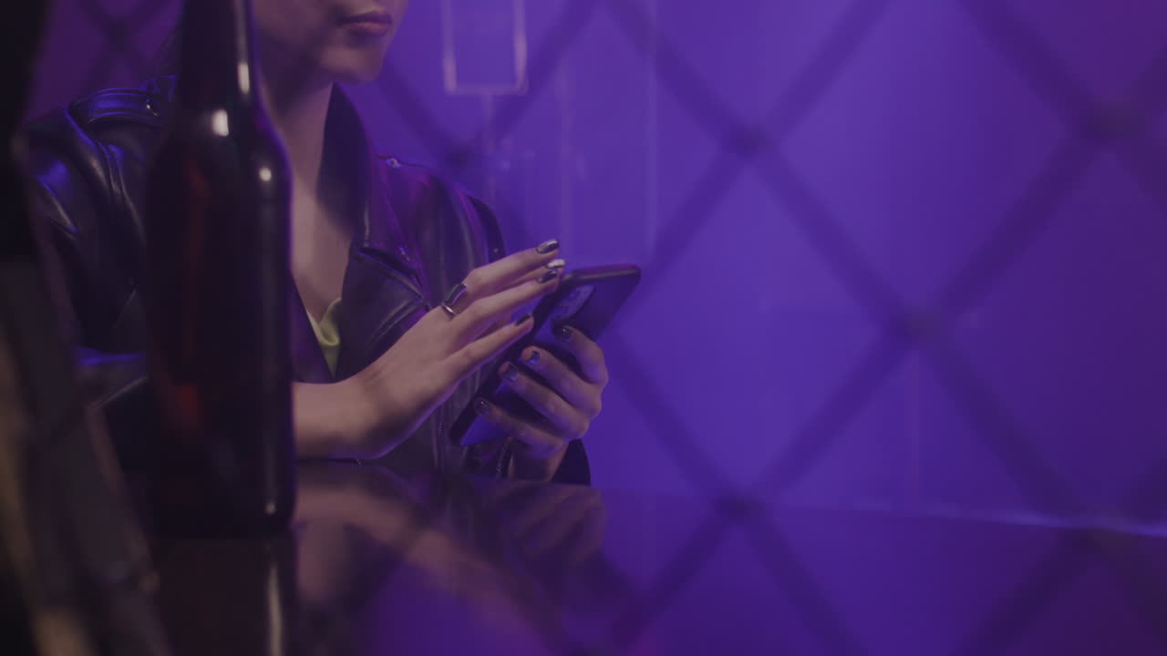 cerca de una hermosa chica usando un teléfono móvil mientras se sienta en la discoteca