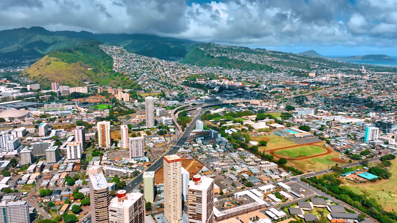 La moderna e vivace Honolulu, Hawaii, USA in una soleggiata giornata. Spettacolare scenario di nuvole che copre le colline sullo sfondo. Prospettiva aerea