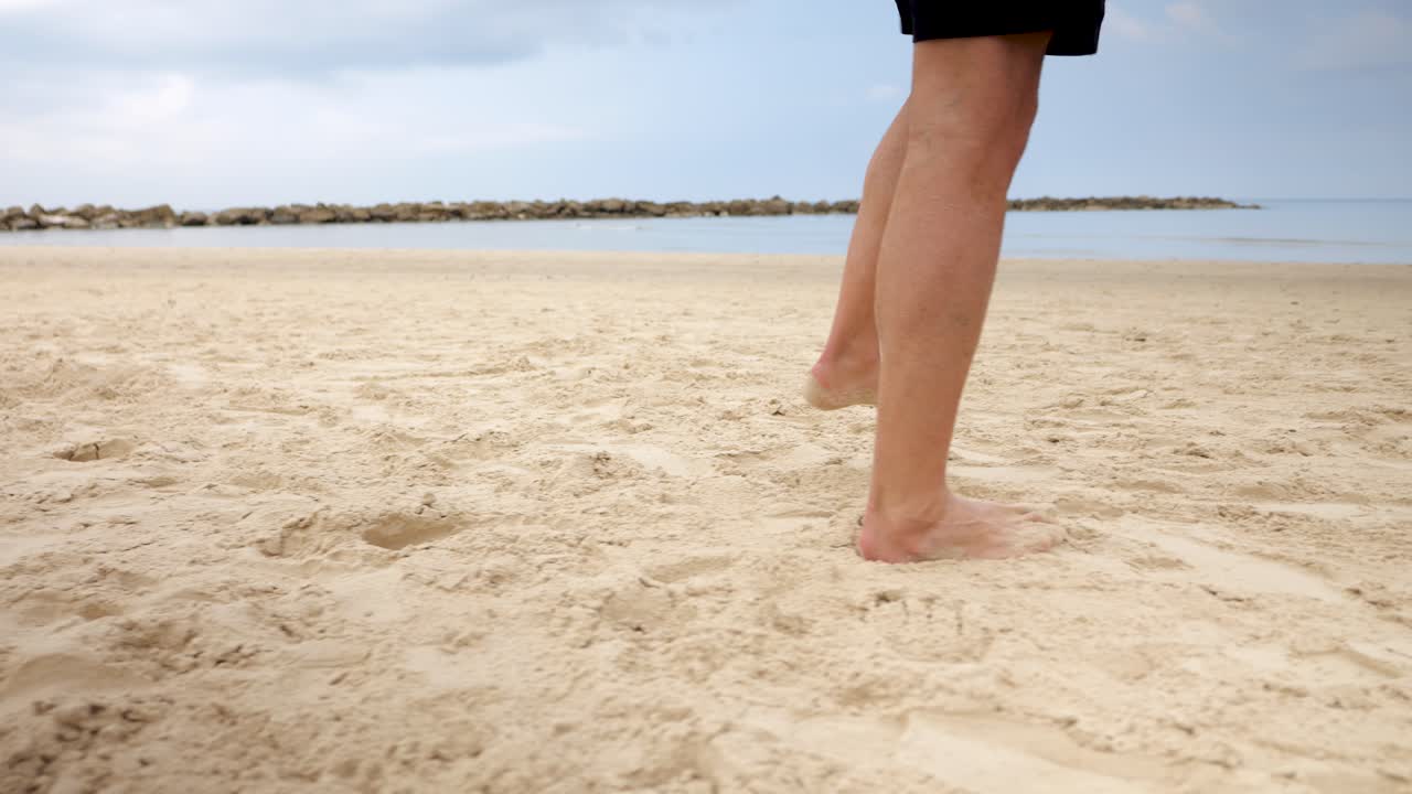 ⁇  모래 해변 을 가로질러 발바닥 을 벗고  ⁇ 고 있다