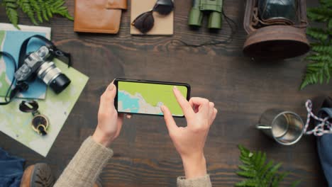 top view of unrecognizable woman using map on phone