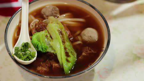 savory beef noodle soup with fresh vegetables