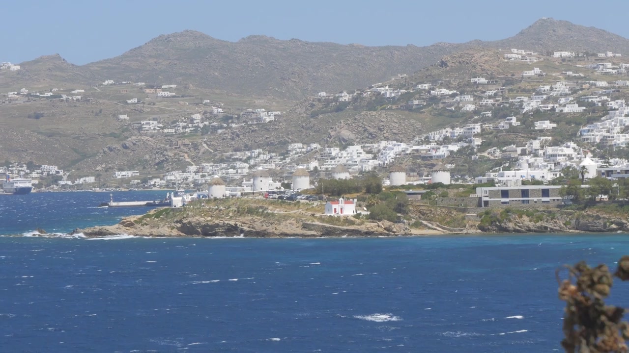 Catturare la bellezza senza tempo di Mykonos, Grecia, con i suoi mulini a vento tradizionali sullo sfondo del Mar Mediterraneo.