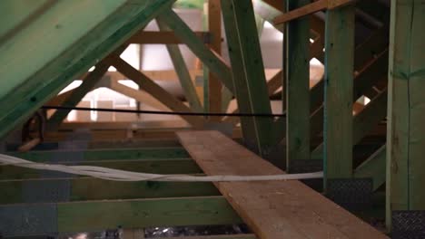 narrow walkway through timber roof trusses inside attic during building construction