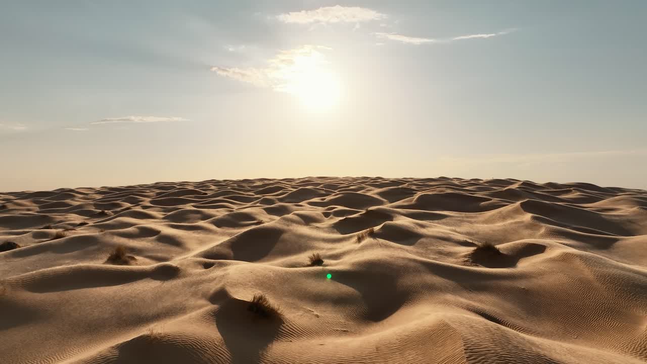 el dron está volando hacia adelante sobre el desierto del sáhara con el viento soplando arena sobre las dunas en un día soleado en túnez imágenes aéreas 4k