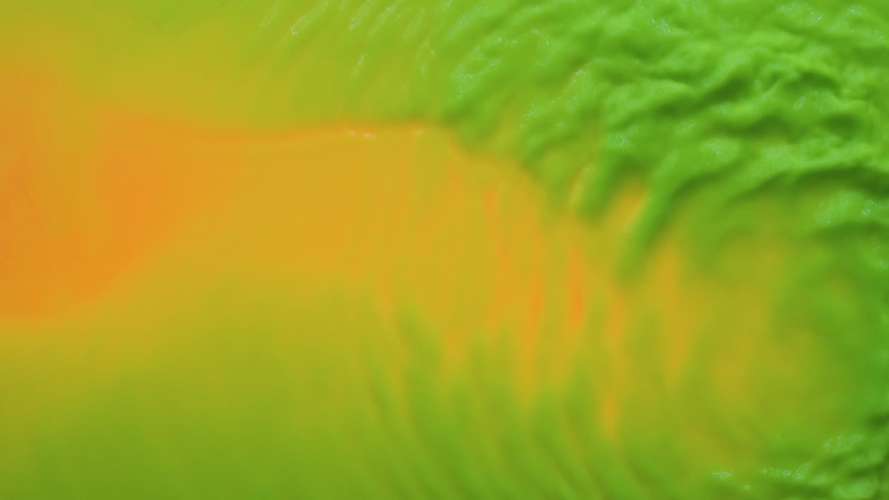 ondas abstractas de pintura de neón verde sobre un fondo amarillo. vista desde arriba.