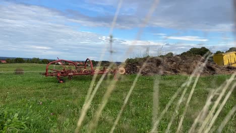 plano general estático de algunos equipos agrícolas y una pequeña colina de estiércol cerca de la ciudad de kaufbeuren, alemania-1