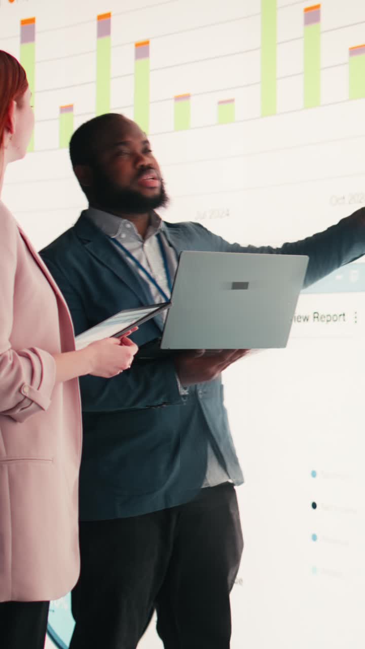 Vertical video Analyzing economic data graphs, laptop and businesspeople
