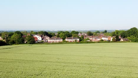 Absteigende-Drohnenaufnahme-Von-Einer-Wunderschönen-Grünen-Wiese-Mit-Blick-Auf-Wohnhäuser-Im-Crouton-Village-Farmland-Im-Vereinigten-Königreich-An-Einem-Sonnigen-Tag