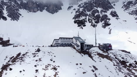 Nordkette-Cable-Car-Station-at-Snowy-Austrian-Mountain-AERIAL-PULLBACK