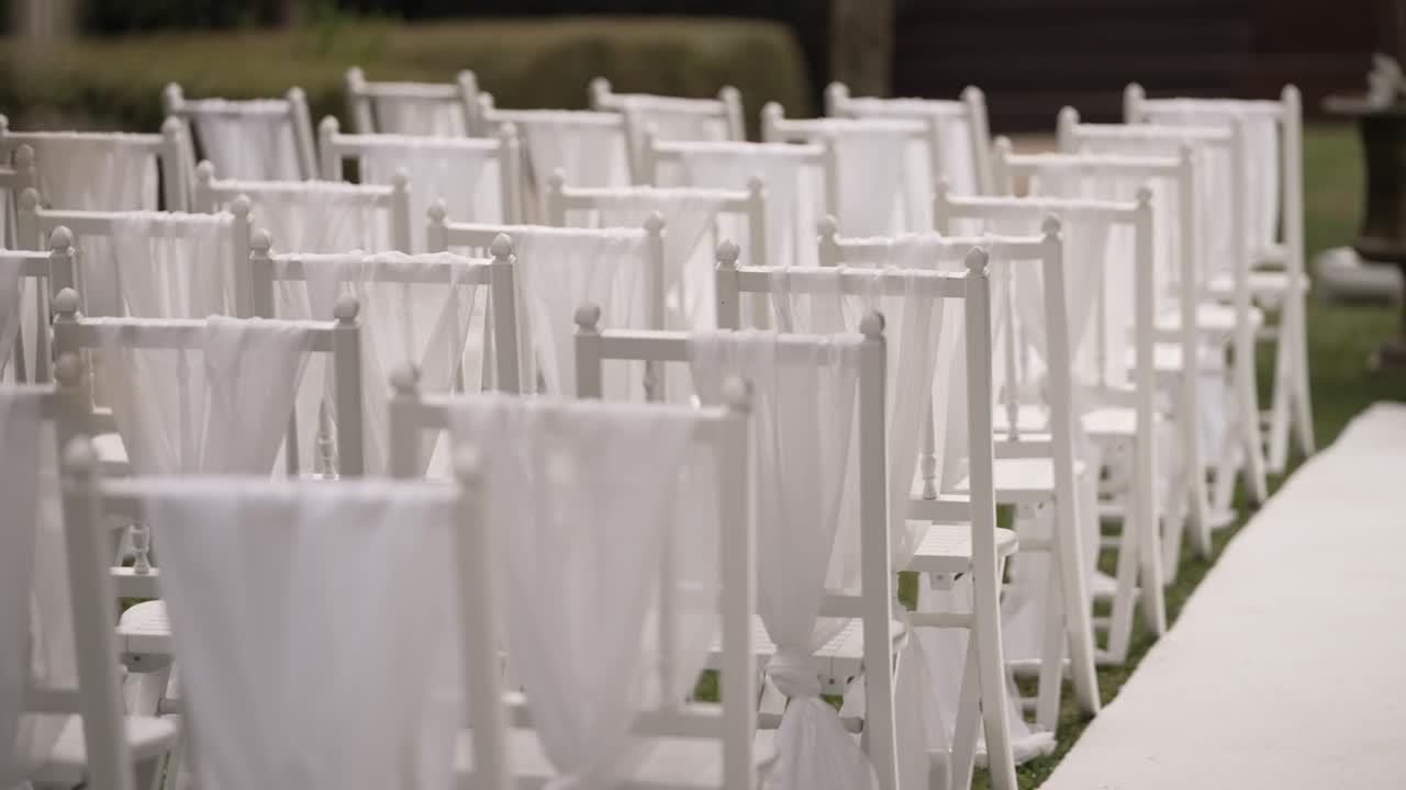 White Chairs Set Up for an Outdoor Wedding Ceremony