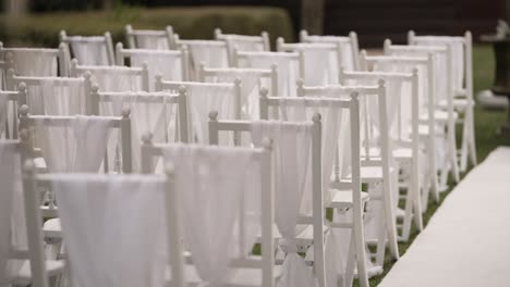 white chairs set up for an outdoor wedding ceremony