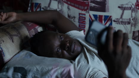 man using phone while in bed