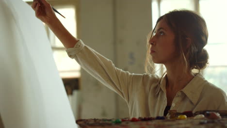 Focused-woman-painting-on-canvas.-Creative-female-artist-working-in-art-studio.