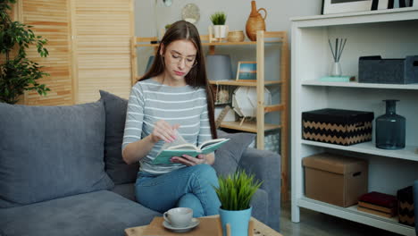 woman reading a book on a sofa in a cozy living room
