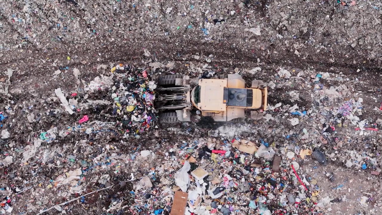 Loader moves mixed refuse at landfill, showing scale of plastic pollution crisis