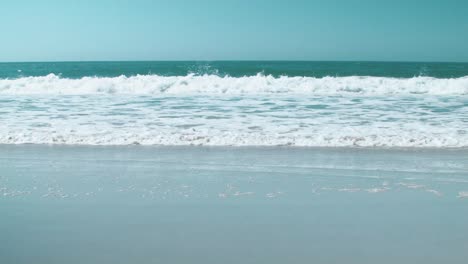 Waves-on-the-shoreline-come-toward-the-camera-on-the-shore-of-a-beach-in-Nazaré,-Portugal