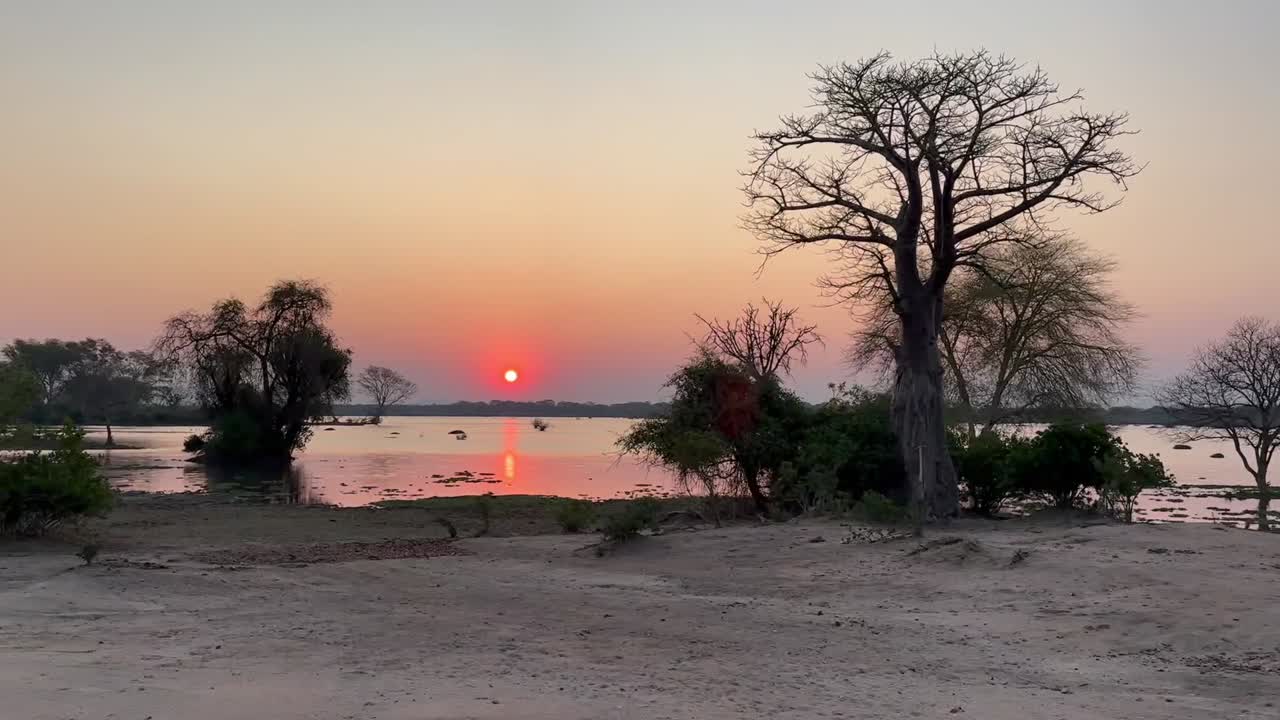 puesta de sol sobre el río shire en el parque nacional de liwonde, malawi.