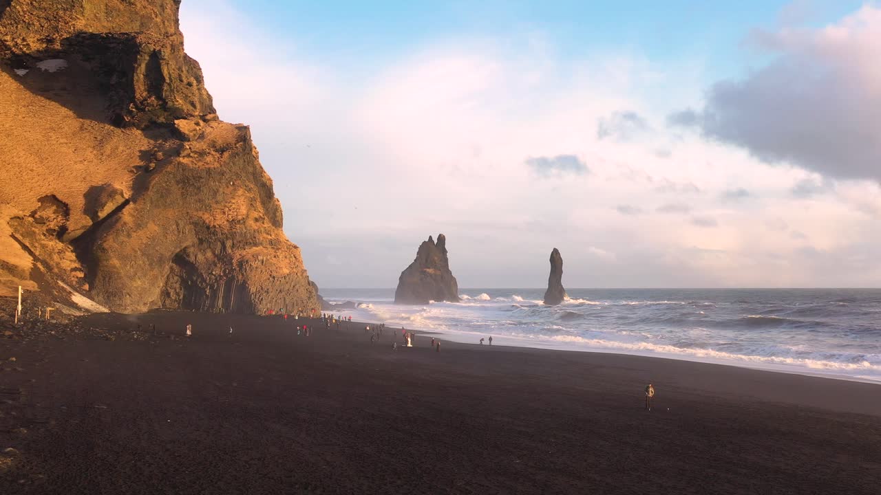 Roaming Iceland's Black Sand Beach: Aerial Footage of Wanderers - Captured by Drone