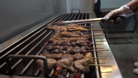 voltear peces con pinzas en la parrilla con pinchos