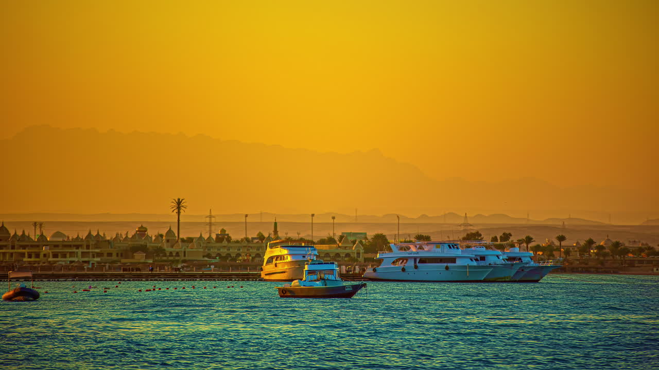 yate y bote pequeño anclados en el mar durante el amanecer dorado