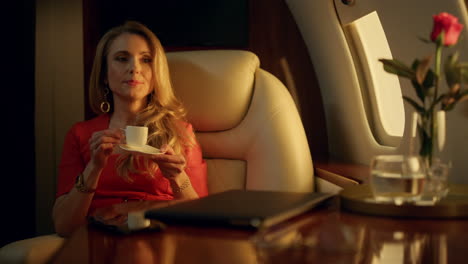 mujer atractiva disfrutando de un café a la luz del sol dorado. mujer de lujo descanso avión