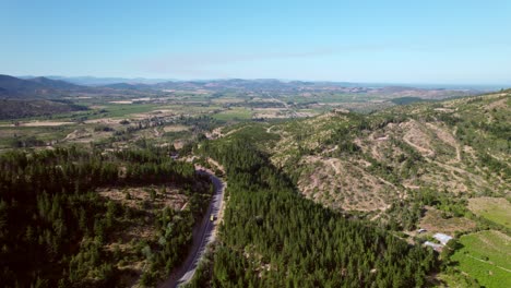 establishing shot of a road running through the maule valley vineyards and mountains