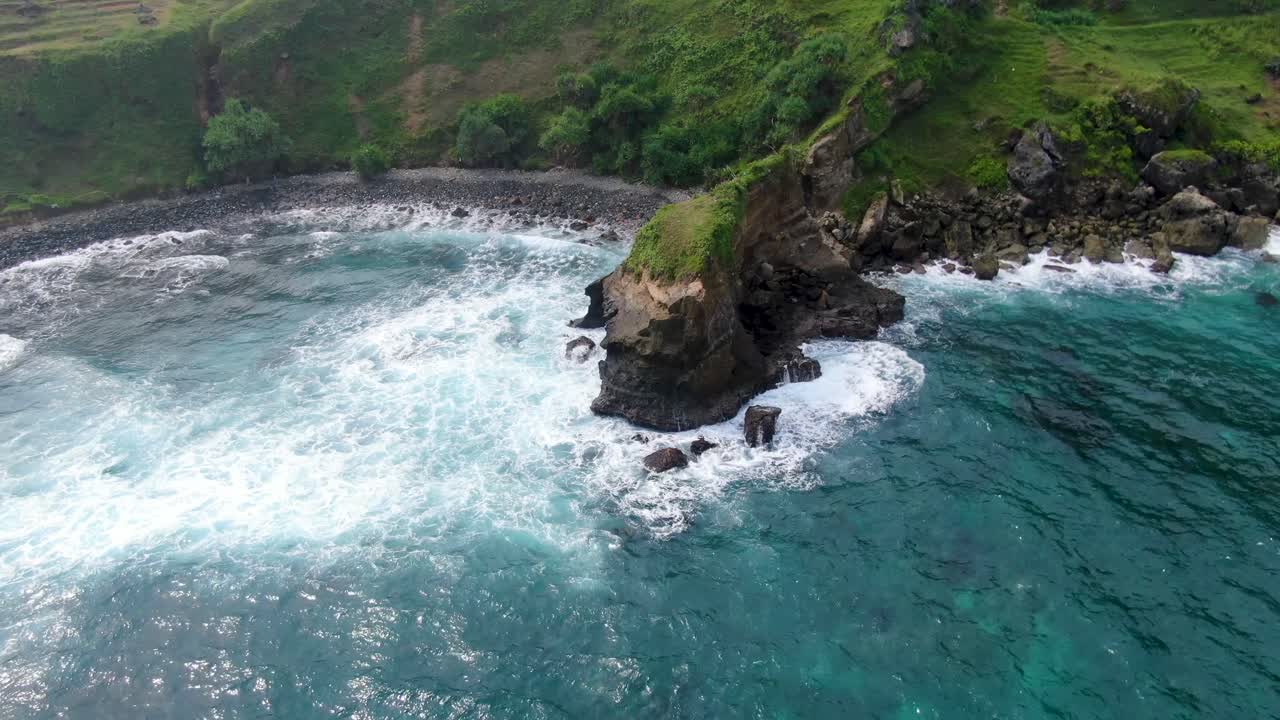 Waves breaking on rocky cliffs at Menganti beach, Kebumen in Indonesia