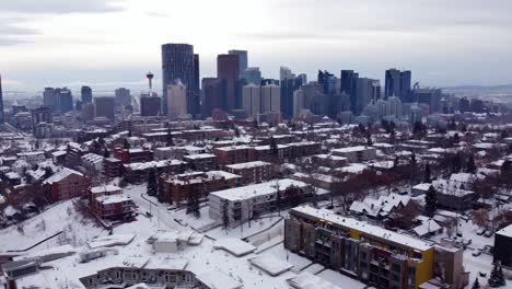 Volando-Hacia-El-Centro-De-Calgary-Sobre-Casas-Cubiertas-De-Nieve